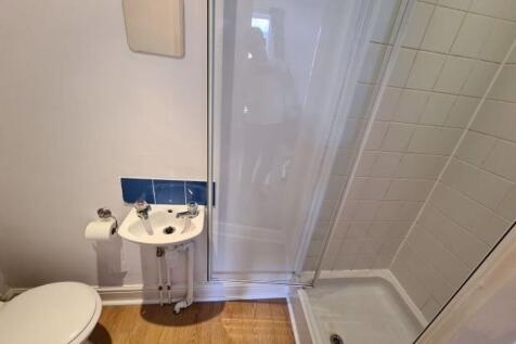 Compact, well-maintained bathroom with a corner...
