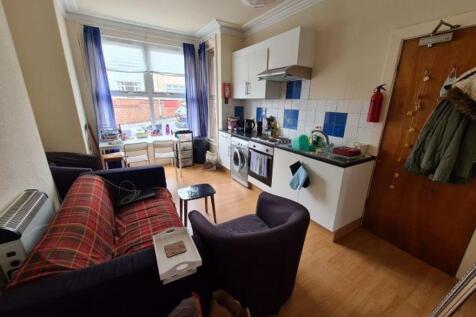 Bright, open-plan living area with a fitted kit...