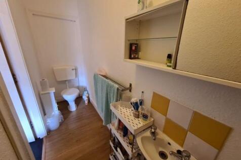 Compact bathroom with a toilet, sink with vanit...