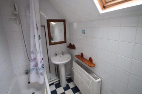 Bright upstairs bathroom with a skylight, white...