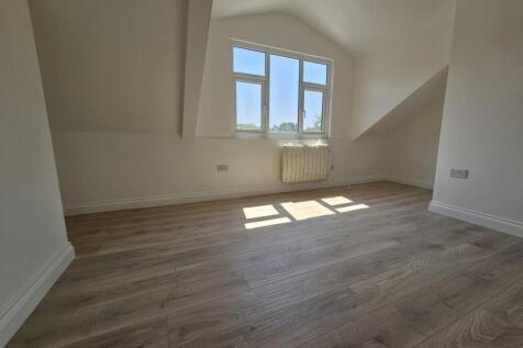Bright top-floor bedroom with light wood floori...