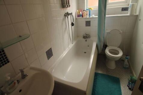 Bright bathroom with a full-size bathtub, showe...