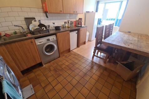 Functional kitchen with tiled floor, wooden cab...