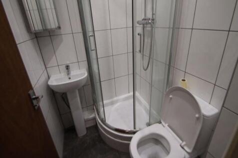 Compact, modern bathroom with a corner glass sh...