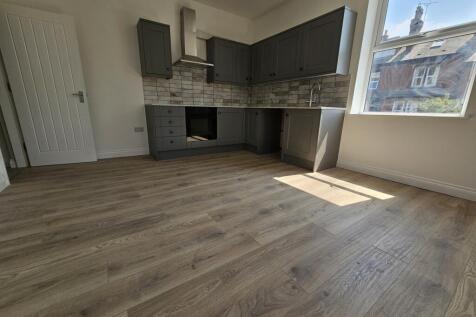 Bright open-plan kitchen with modern grey fitte...