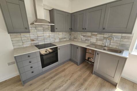 Modern fitted kitchen with grey shaker-style ca...