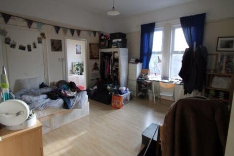 Spacious, well-lit bedroom with large window, f...