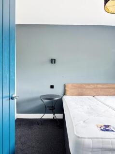 Bright, simply styled bedroom with a comfortabl...