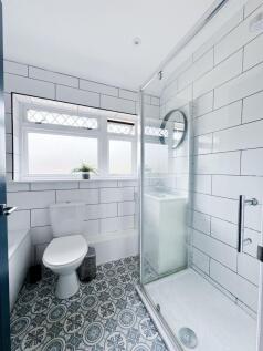 Bright, modern bathroom with patterned tiled fl...