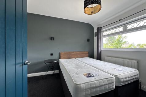 Bright, freshly styled bedroom with two comfort...