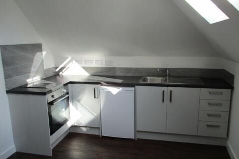 Modern kitchen area featuring a sleek black cou...