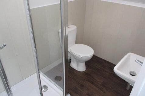 A clean, modern bathroom featuring a shower enc...