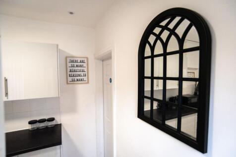 Bright, modern kitchen corner with white cabine...