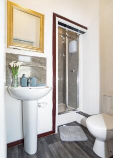 Bright, modern bathroom with a pedestal sink, f...