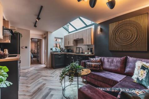 Stylish open-plan living area with a plush purp...