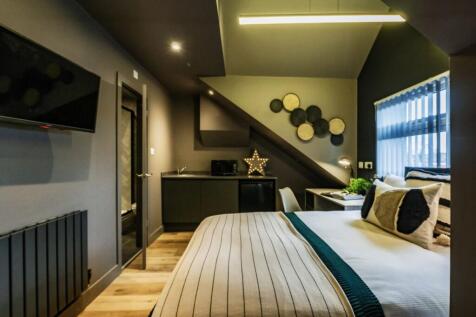 A spacious and stylish master bedroom featuring...