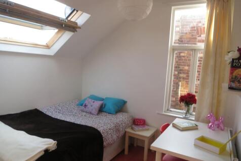 Bright and cozy bedroom featuring natural light...
