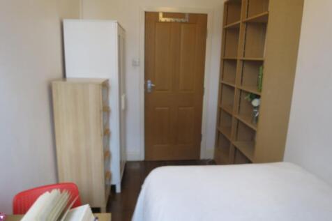 A cozy and tidy bedroom featuring a bed, a wood...