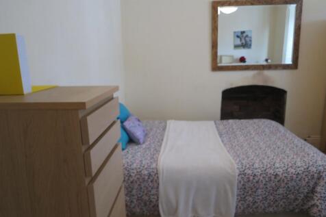 A cozy double bedroom featuring a wooden wardro...