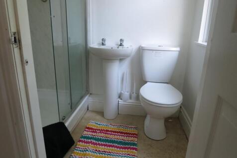 Clean and bright bathroom featuring a shower wi...