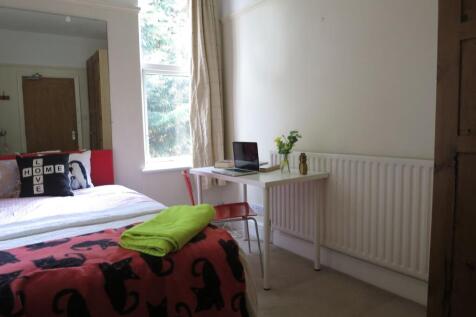 A cozy bedroom featuring a double bed draped wi...