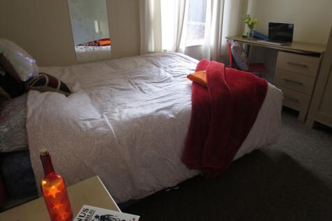 Spacious master bedroom featuring a large bed w...