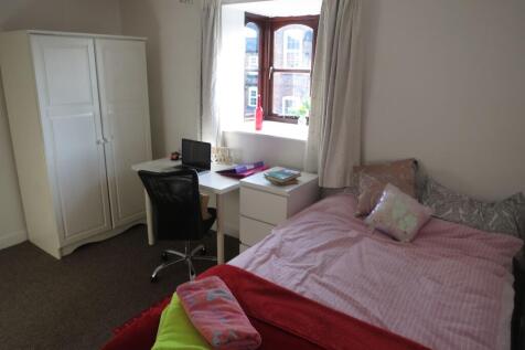 A cozy and well-maintained bedroom featuring a ...