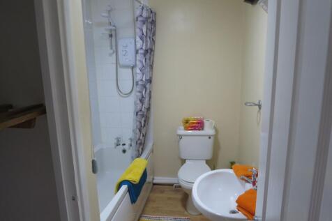 A tidy and functional bathroom featuring a bath...