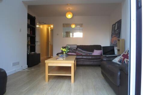 A spacious, well-lit living room featuring two ...