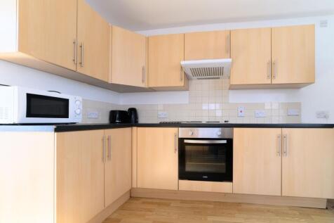 A modern, clean kitchen featuring wooden cabine...
