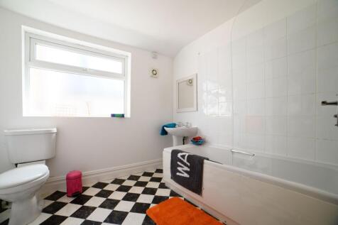 Bright and tidy bathroom featuring a toilet, si...