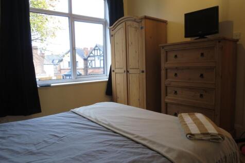 A cozy bedroom featuring a large window that al...