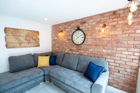 A stylish living room featuring a spacious grey...