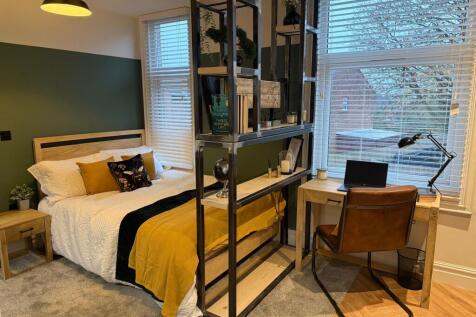 A cozy student bedroom featuring a comfortable ...