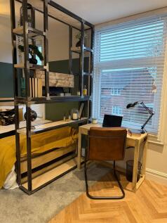 A well-lit, cozy single bedroom featuring a com...