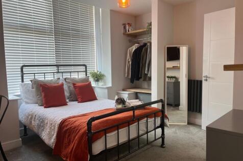 Bright and modern master bedroom featuring a st...
