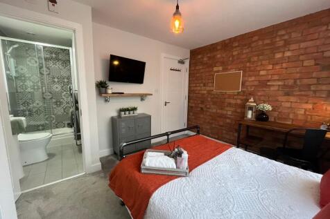 A stylish and inviting bedroom featuring a cozy...