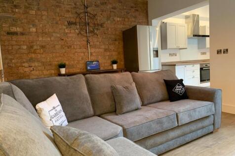 A spacious, well-maintained living room with a ...