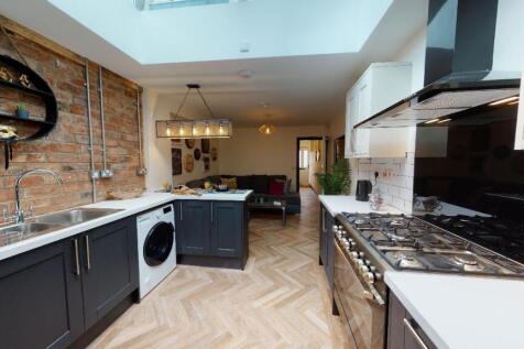 Modern kitchen featuring sleek black cabinets, ...