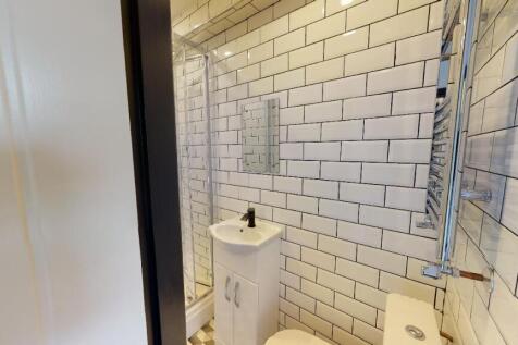 A modern, clean bathroom with white subway tile...
