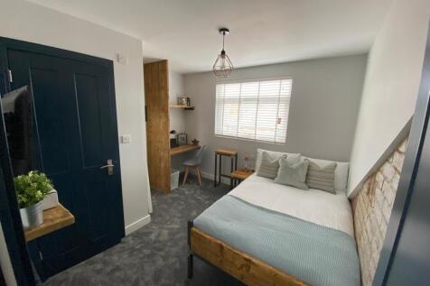 A modern, well-lit bedroom featuring a comforta...