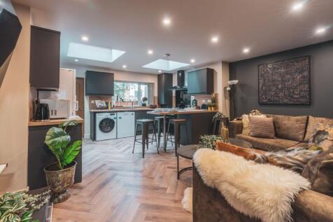 A spacious, modern living room with ample natur...