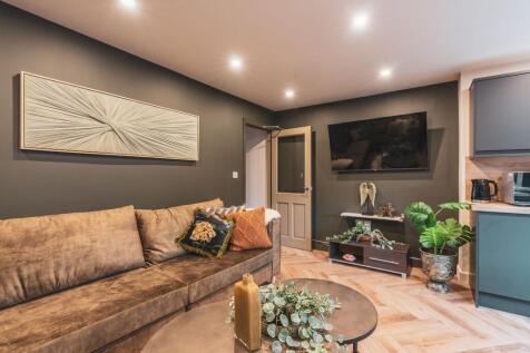 A modern, well-lit living room featuring a comf...