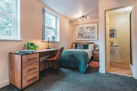 A cozy and well-lit bedroom featuring a comfort...