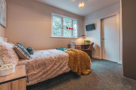 A cozy bedroom featuring a comfortable bed with...