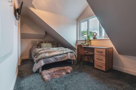 A cozy, well-maintained bedroom with a comforta...