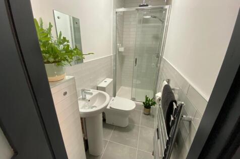 Modern tiled bathroom with a walk-in glass show...