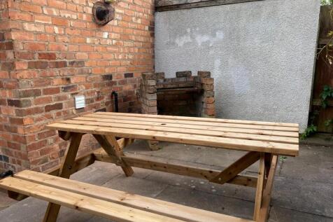 Private paved garden corner with a sturdy woode...