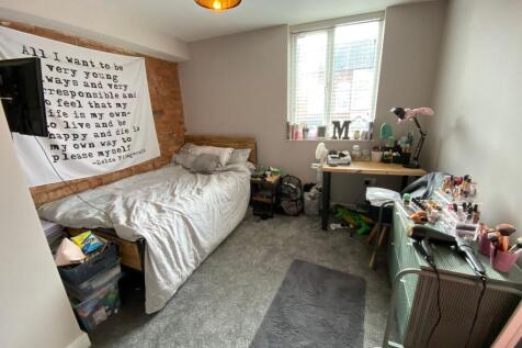 A cozy bedroom featuring a comfortably made bed...