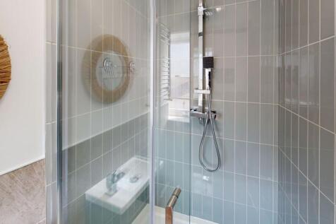 Modern bathroom featuring a walk-in shower with...